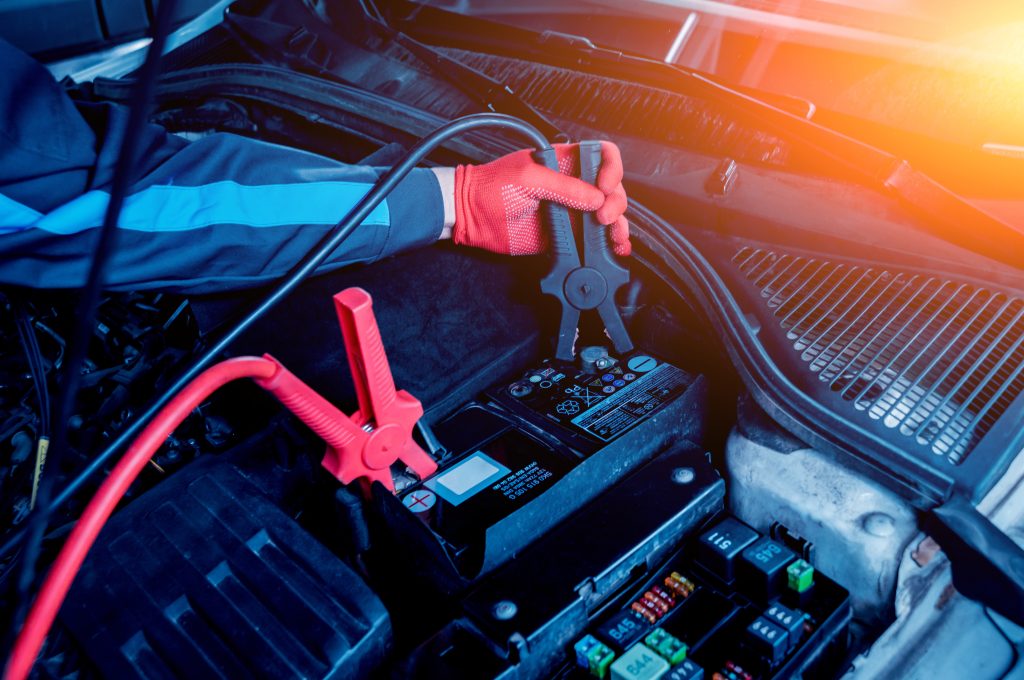 Jump-starting a car battery with jumper cables.