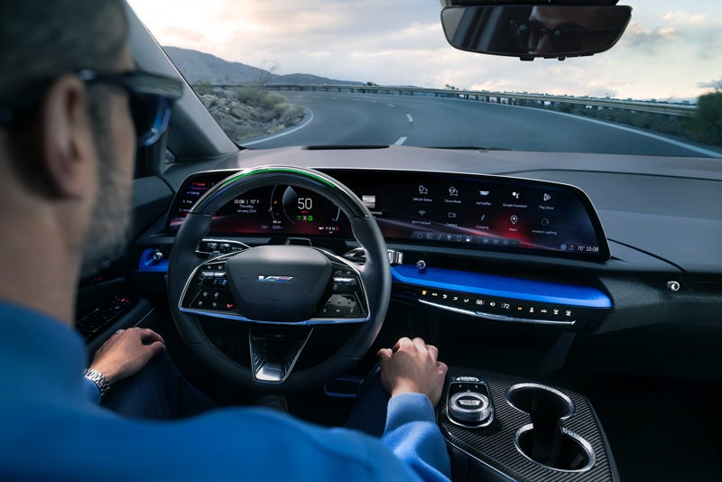 Front View of the 2026 OPTIQ-V Driving Through the Dusk Utilizing its Headlights | Carroll Cadillac of North Orlando in SANFORD FL