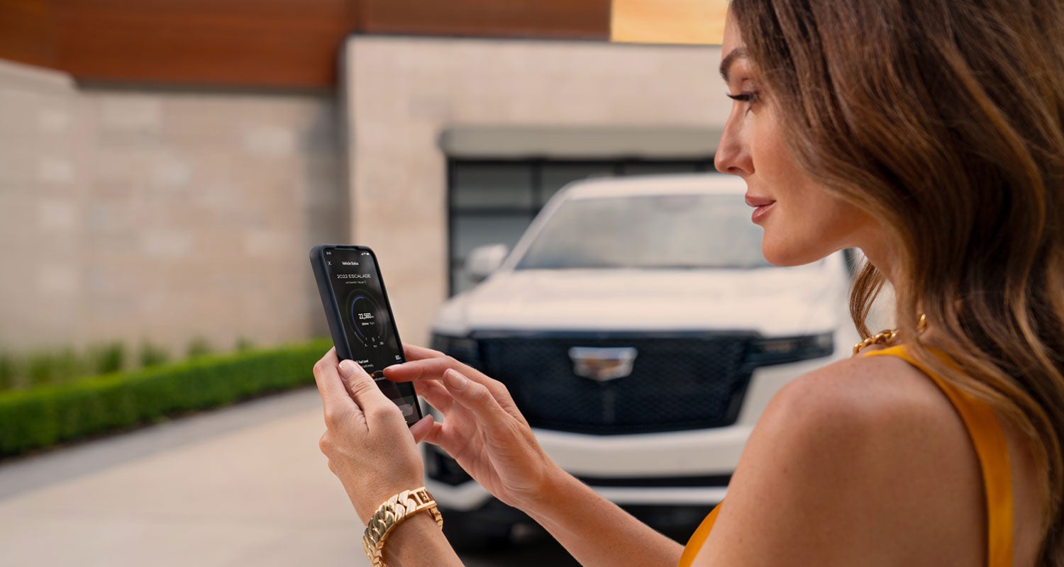 lady checking her mobile with a Cadillac vehicle background | Carroll Cadillac of North Orlando in SANFORD FL